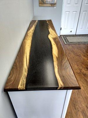 River top to the farmhouse entertainment center. Made out of walnut wood and black onyx epoxy.