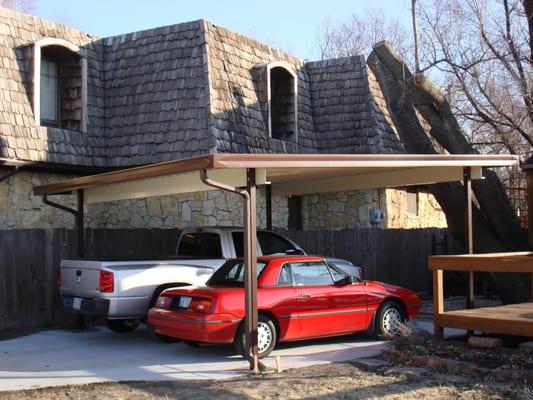 Carport with 10" c-beams, built in guttering, and steel top.