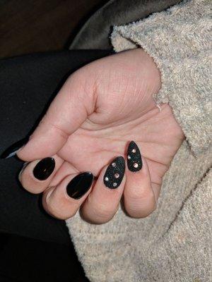 Black acrylic gel nails with two black glitter nails and rhinestones