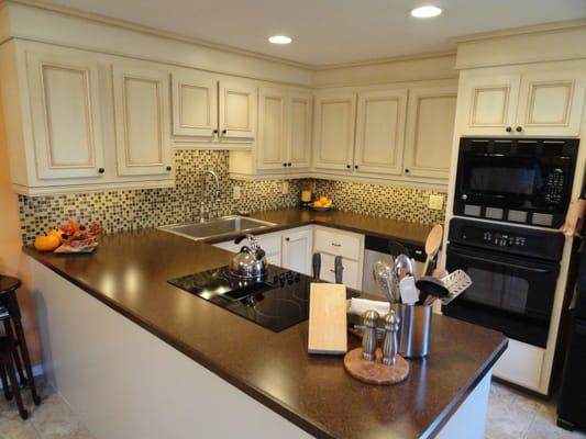 AFTER: Mission Accomplished! Wall Removed. Cabinets Refaced. Glass Tiled Back-splash. New Counter Top added.