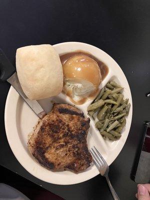 Pork Chop plate with a scoop out of the mashed potatoes