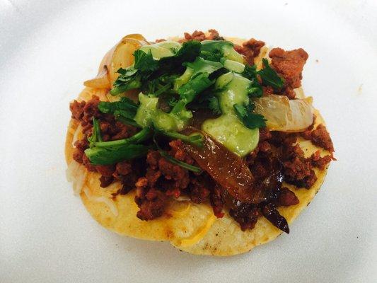 Tostaditas, cheese, Al pastor, grilled onions, avocado salsa, and cilantro