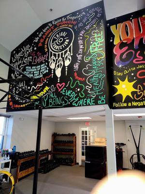 Colorful mural with inspirational quotes inside the gym.