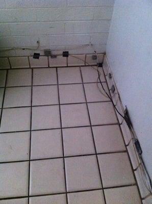 Bathroom floor with cables held on by duct tape