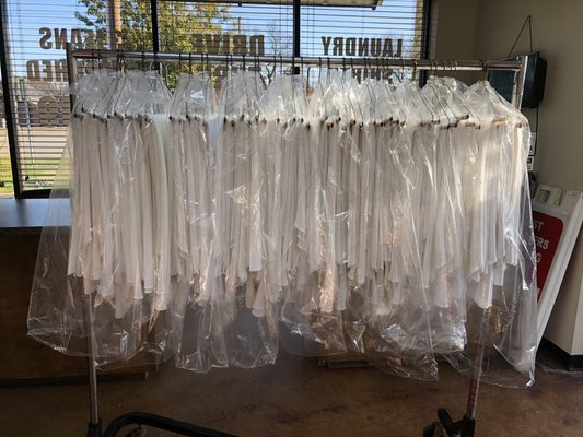 50 dry cleaned table cloths, hanged & ready for delivery.