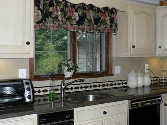 New window treatment and decorative insert makes for a beautiful kitchen