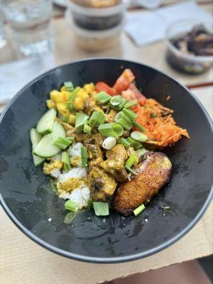 Sizzlin' Someting bowl with curry chicken, ginger carrot slaw, marinated tomato, cucumber, fried plantain, mango, and green onion