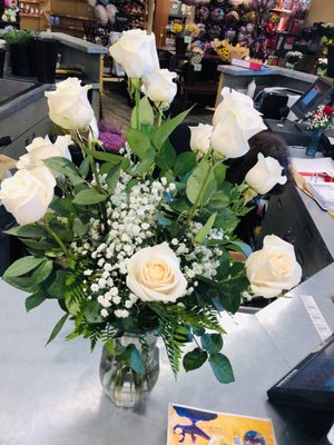 White dozen roses with greens.