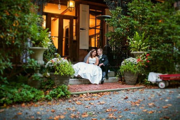 Bride and groom sitting on the steps during their fall wedding at Faunbrook Bed & Breakfast