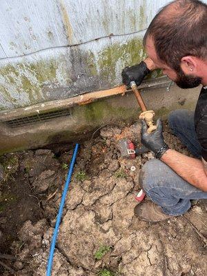 Making sure the new PEX line is secure on the hose bib before finishing it up