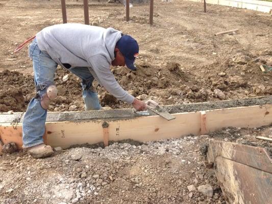 Foreman Javier Mendez edging and finishing playground curb