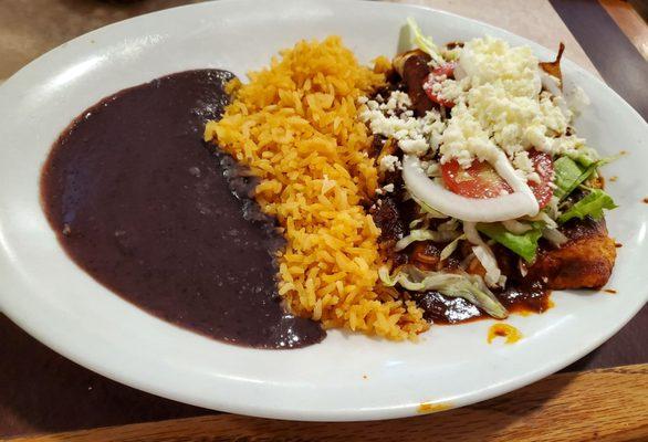 Lunch portion of red mole enchiladas w/black refried beans & rice.