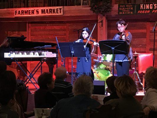 Student and teacher performing violin together at our recital at Dosey Doe!