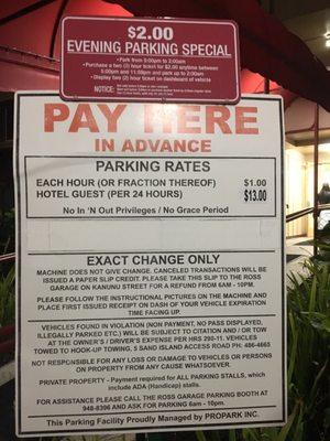 Sign is clearly attached on top of the Propark rates sign. Not behind or above, on top, overlapping.