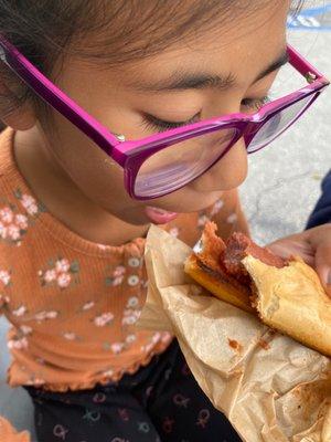 My daughter eating a hotdog