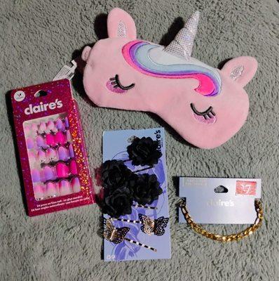 Unicorn sleeping mask, press on nails, hair clips, and a bracelet.