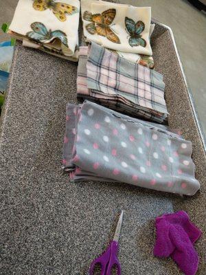 I wiped down the folding table with a wet cloth I brought with me first then cut fabric to make preemie blankets out of.