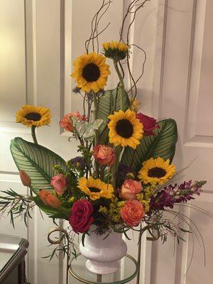 Modern funeral arrangement with bold sunflowers