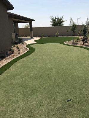 Custom Back yard.
 Artificial turf, Putting green, Travertine patio, Rock, plants, outdoor lighting.