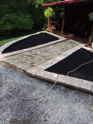 Here is a brick patio/sidewalk with a small retaining border and new mulch added.