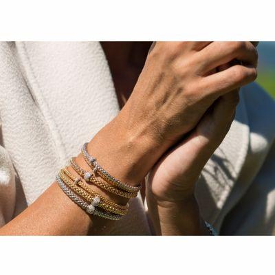 An elegant stack of bracelets featuring FOPE's original and patented "roll on" mesh chain, crafted solely in 18k gold.