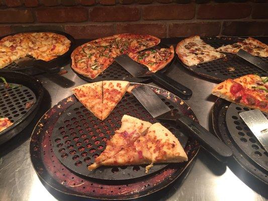 The two pizzas in the middle have been sitting for at least 1 hour.