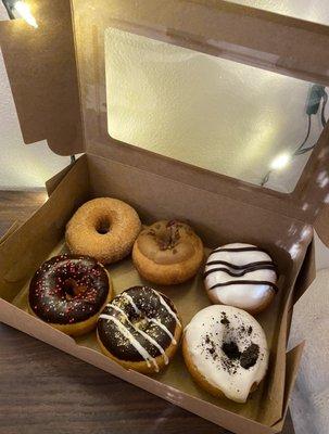 Half-dozen donuts with plain, maple bacon, striped, chocolate, s'mores, and cookies and cream.