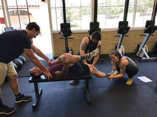 Super friends stretch each other out after class.