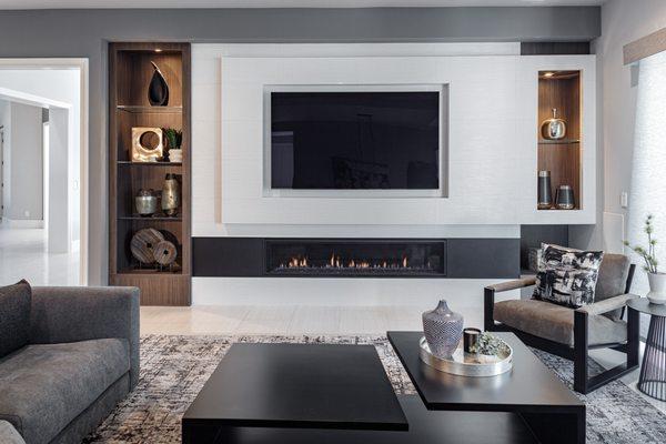 Asymmetrical fireplace design, linear fireplace, recessed large screen TV create a family friendly family room.