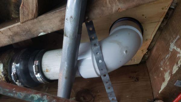 He fixed & attached the new flange to the subfloor, replaced the rusted "J"-pipe, & reattached the new PVC.