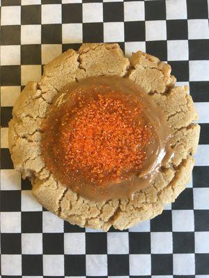 "COOKIE BUTTER" cookie with cookie butter icing and orange sprinkles.