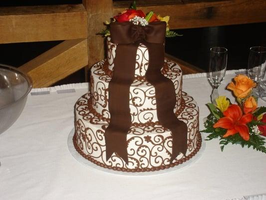 Chocolate scrolls and fondant bow adorn this fall wedding cake.