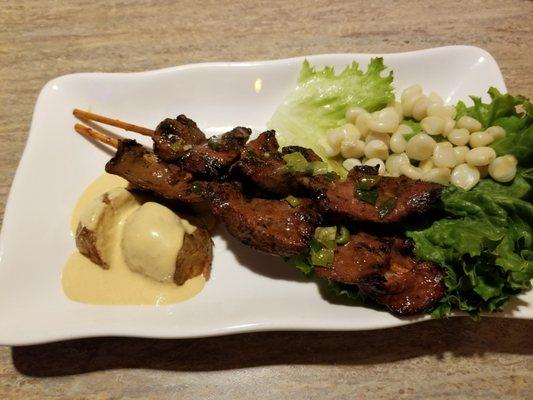 Anticuchos de Corazon.  Skewered BBQed beef hearts served with corn and Huancaina potato.