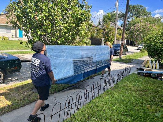 Crew carrying a teak cabinet.