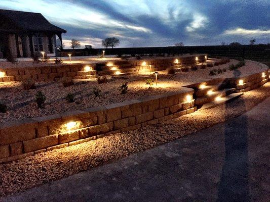 Two-tiered retaining wall with steps and lighting