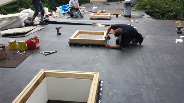 Flat rubber roof in progress with skylights.