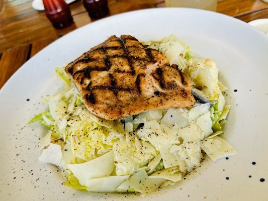 Caesar salad topped with grilled salmon.