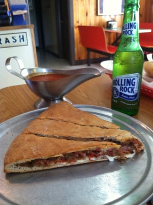 Meat lovers pizza with a side of pizza sauce and a beer. Pizza done right.