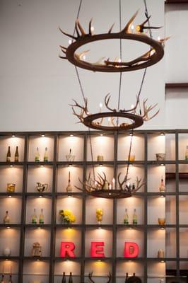 Custom shelving and antler chandelier in airplane hangar birthday party