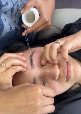 Threading brows. Lupita is really good at reshaping