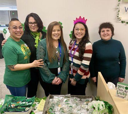 5 employees smile at the St. Patrick's Day event