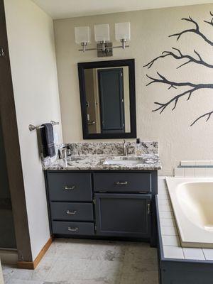 2 vanities and oak surrounding tub painted and warm charcoal gray.