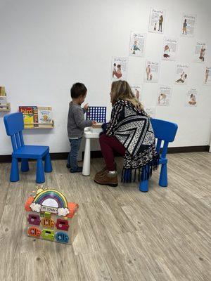 Miss Amanda getting my son to play Connect 4, which has always frustrated him