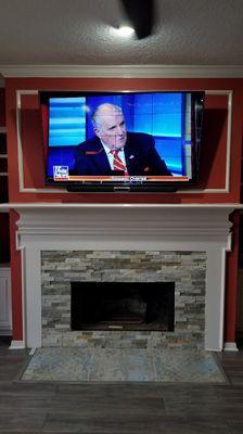 TV mounted above fireplace with soundbar bracket and wire concealment