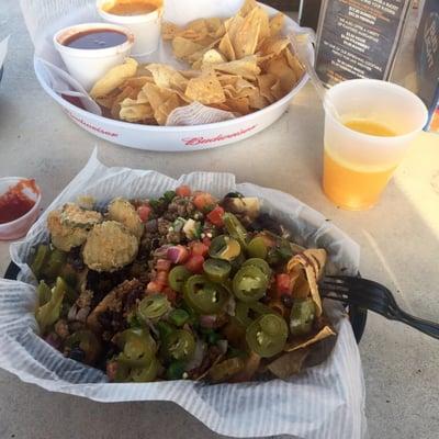 Little Damn Nachos. With a few fried pickle slices. Chips & queso and a mango margarita in the background.