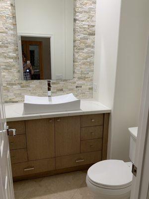 Powder room with custom flat stained cabinetry for contemporary feel.