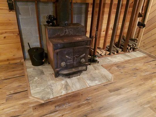 Newly installed LVP flooring and tile highlighting the cozy fireplace