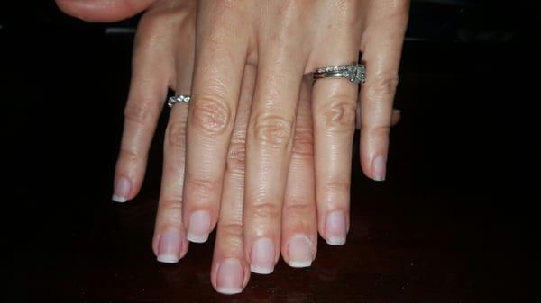 An acrylic overlay on natural nails, call now and receive $10 off new clients.