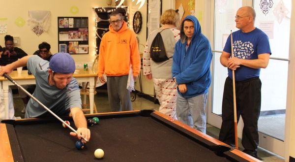 NAMI CGM peers at the pool table.