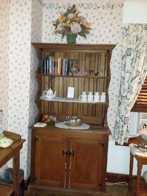 Bookshelf with Pokeno, Parchesi, and Jigsaw puzzles in cabinet.  Coffee mugs for Keurig.